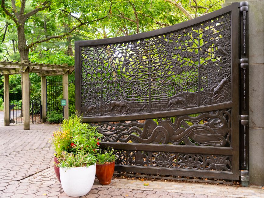 A decorative iron gate with vertical pickets