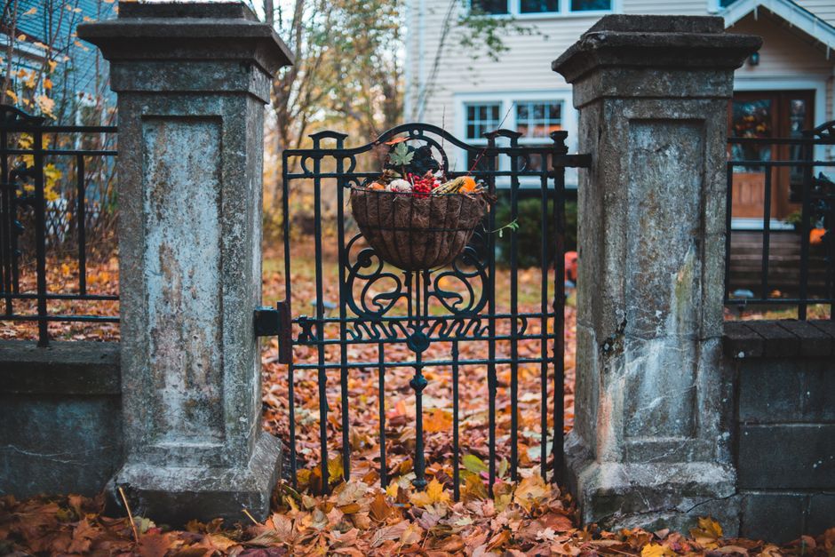 A metal driveway gate beside a masonry post