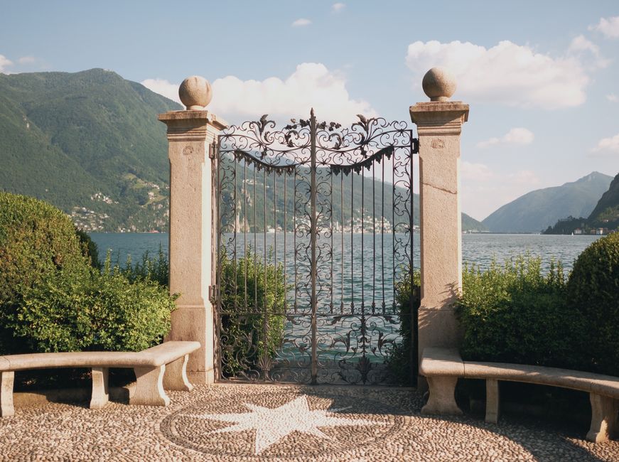 A decorative iron gate with vertical pickets